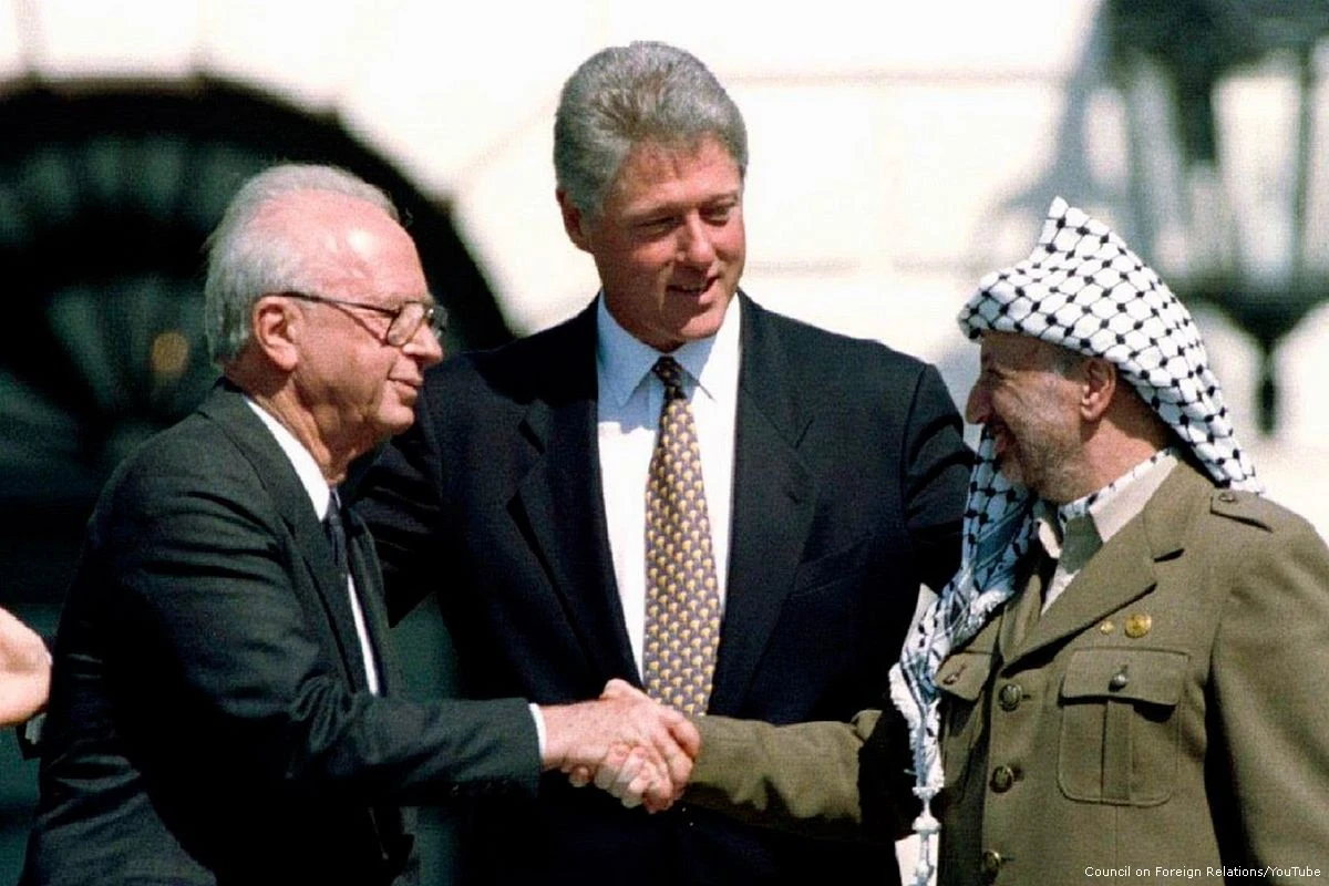 Prime Minister Yitzhak Rabin and Yasser Arafat shaking hands with President Bill Clinton on the White House South Lawn